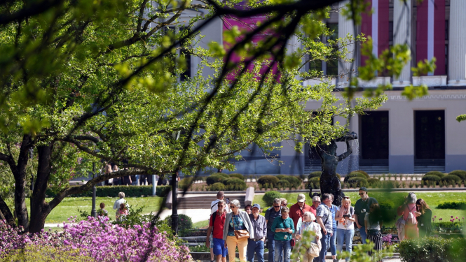 Cilvēki pastaigājas operas skvērā