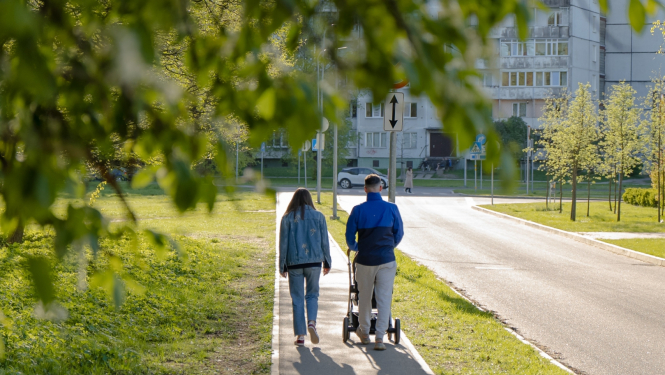 Vecāki pastaigājas ar bērnu ratiņos