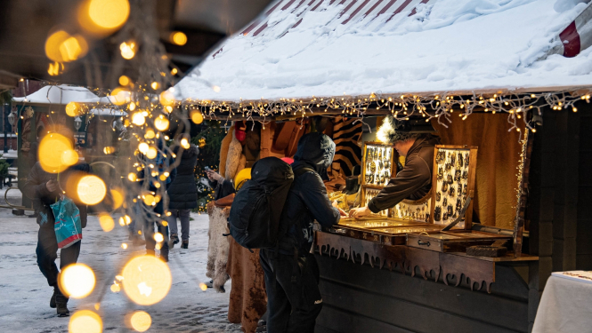 Ziemasvētku tirdziņa būdiņa ar pircēju