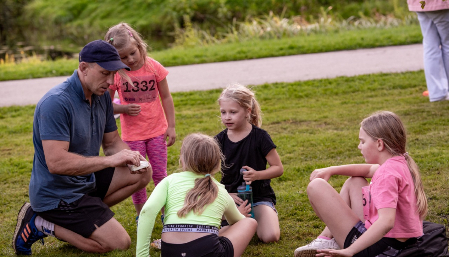 Bērni sēž uz zemes un sarunājas