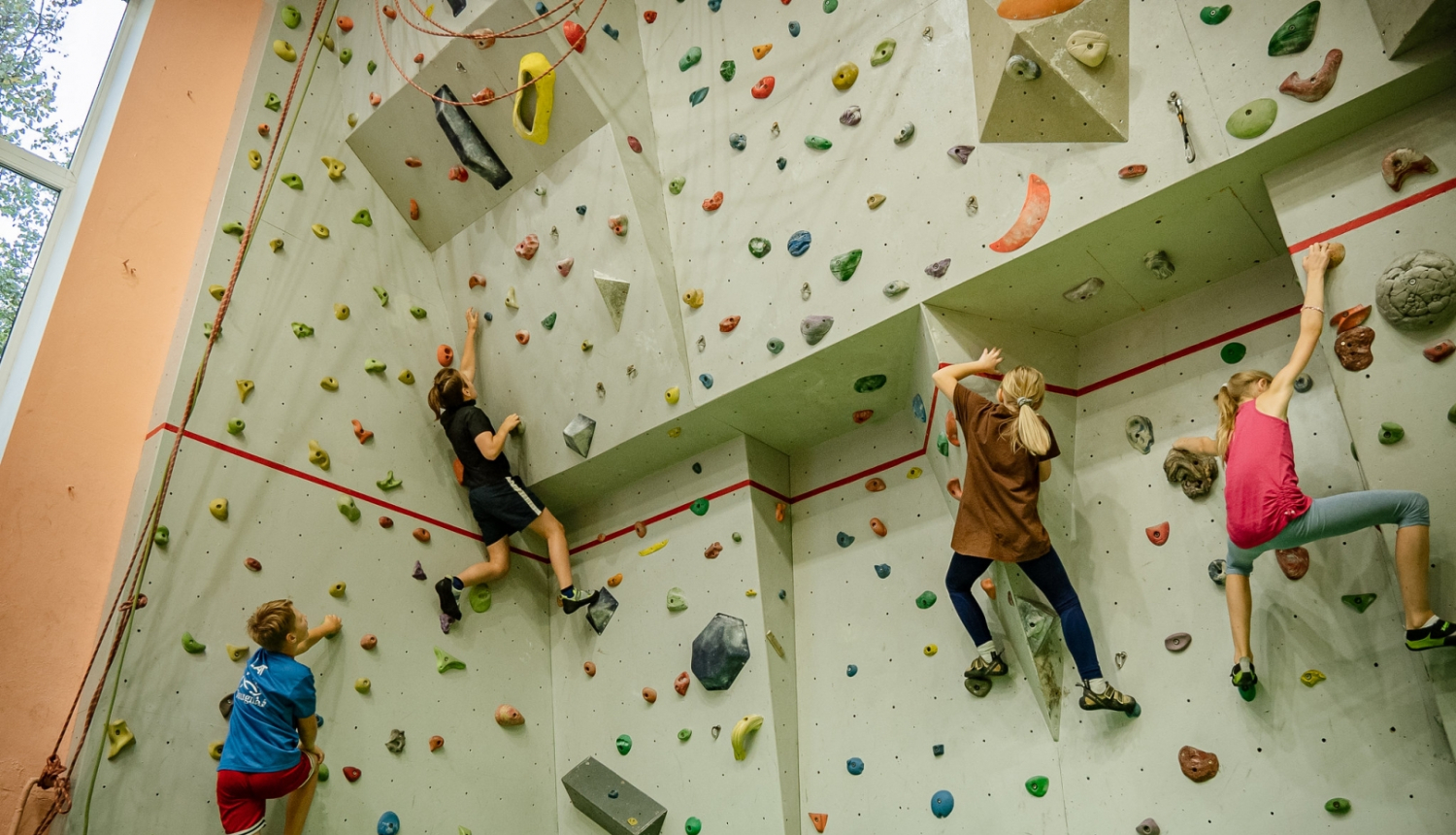 Bērni kāpj pa klitskāpeju sienu