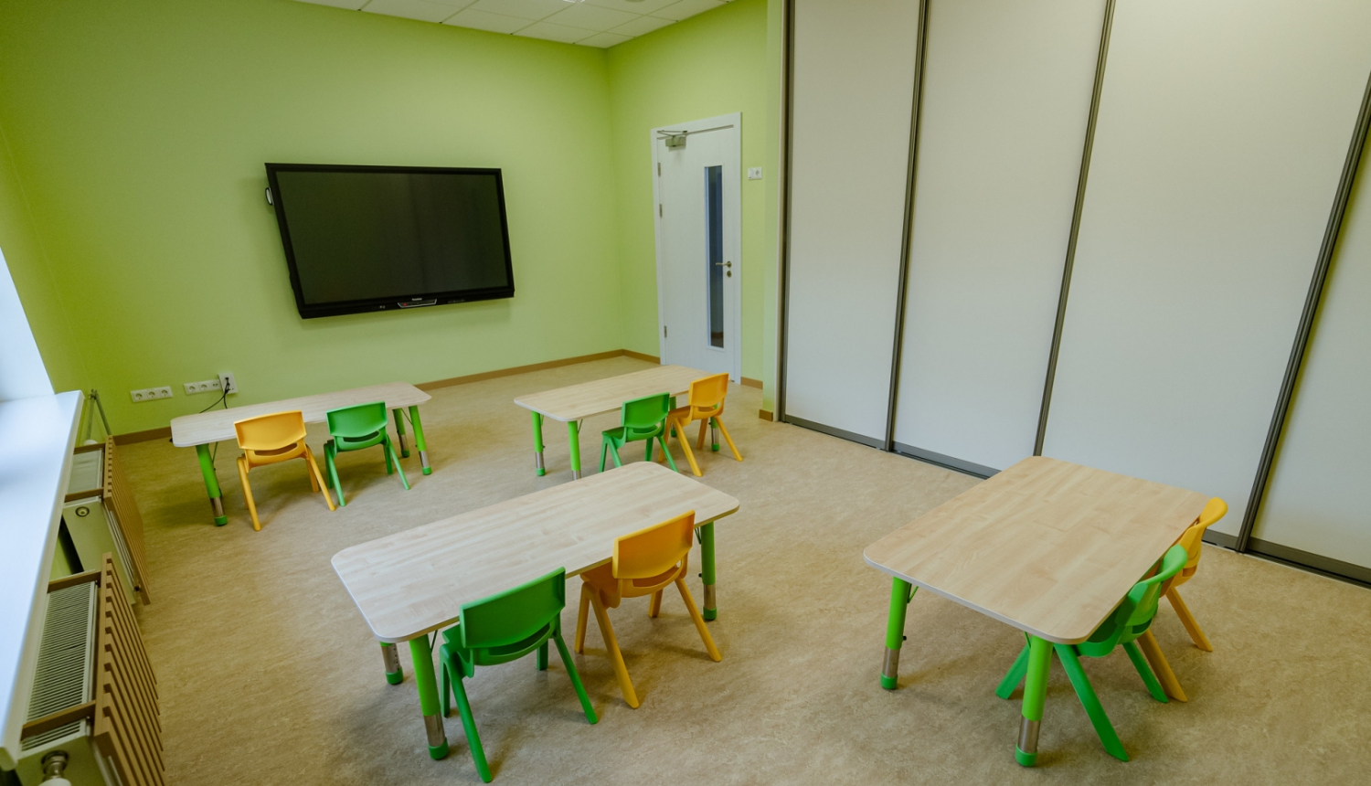 Bērnudārza grupiņa ar galdiem un krēsliem