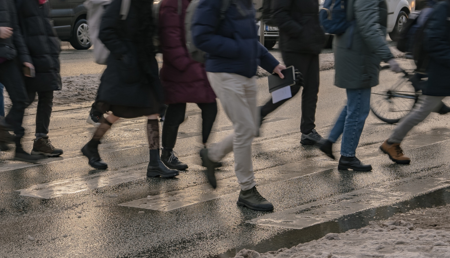 Cilvēki iet pāri gājēju pārejai