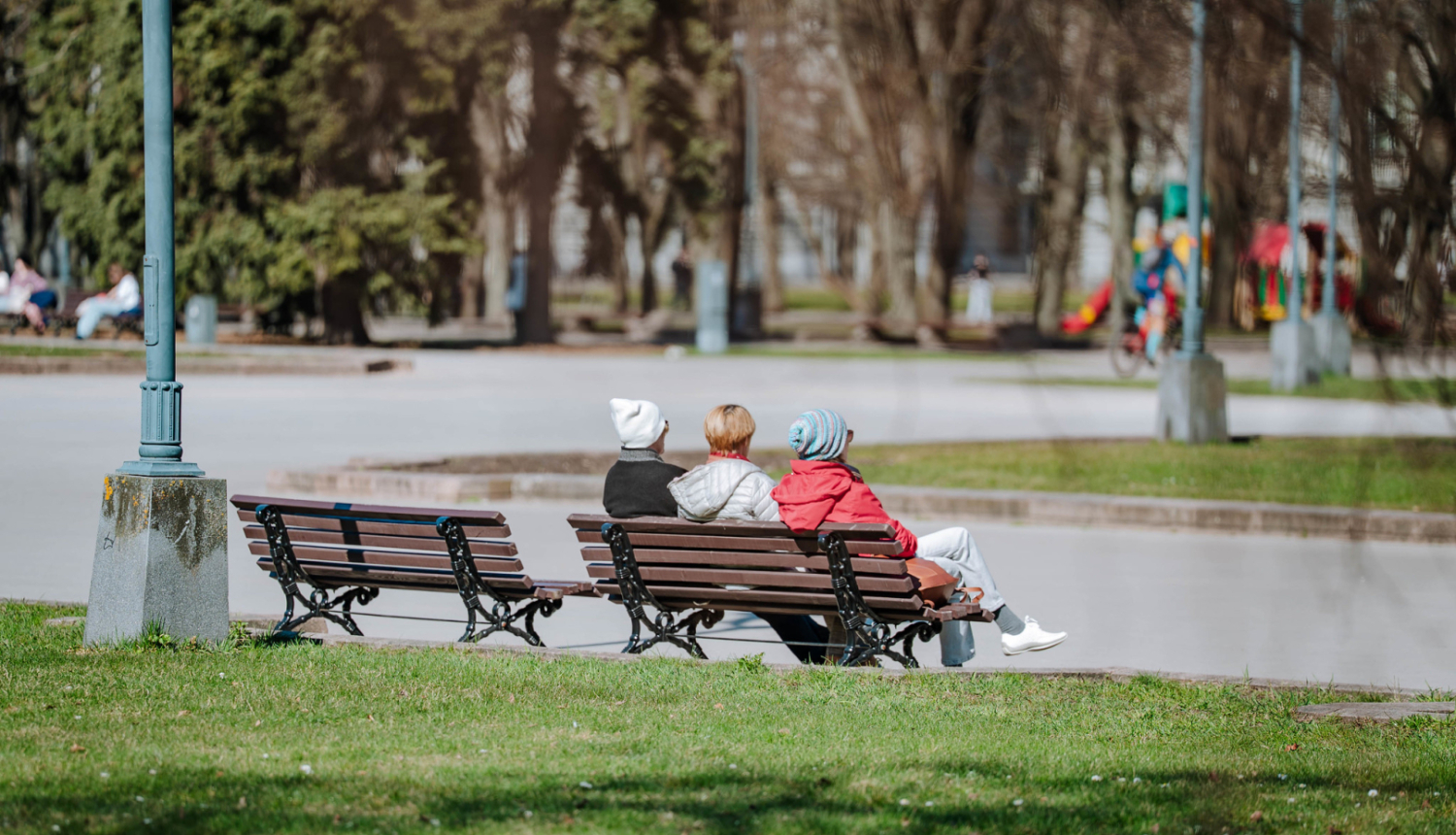 Cilvēki sēž uz soliņa