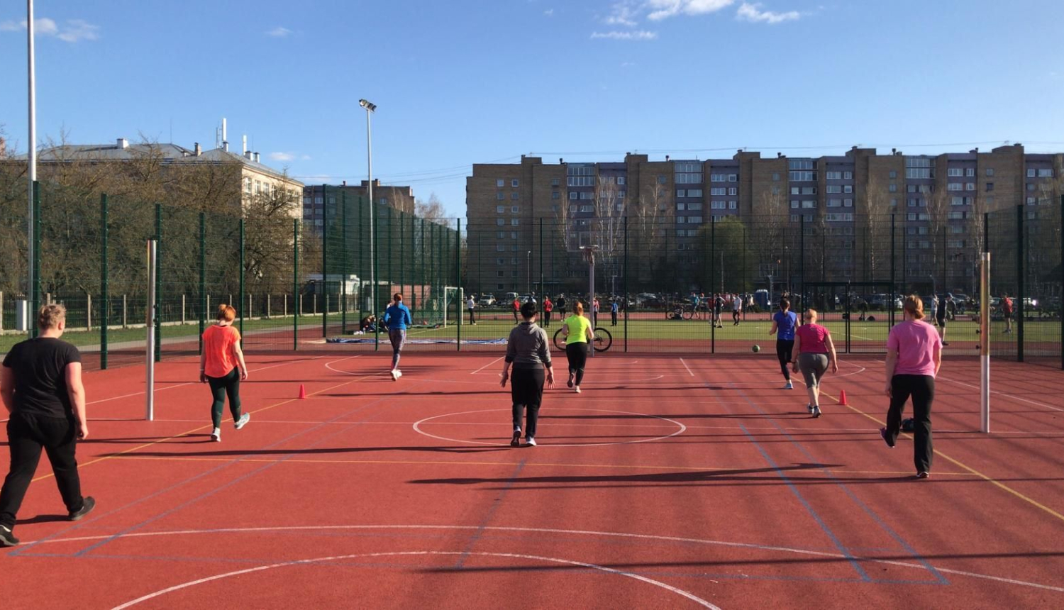 Cilvēki vingro sporta laukumā