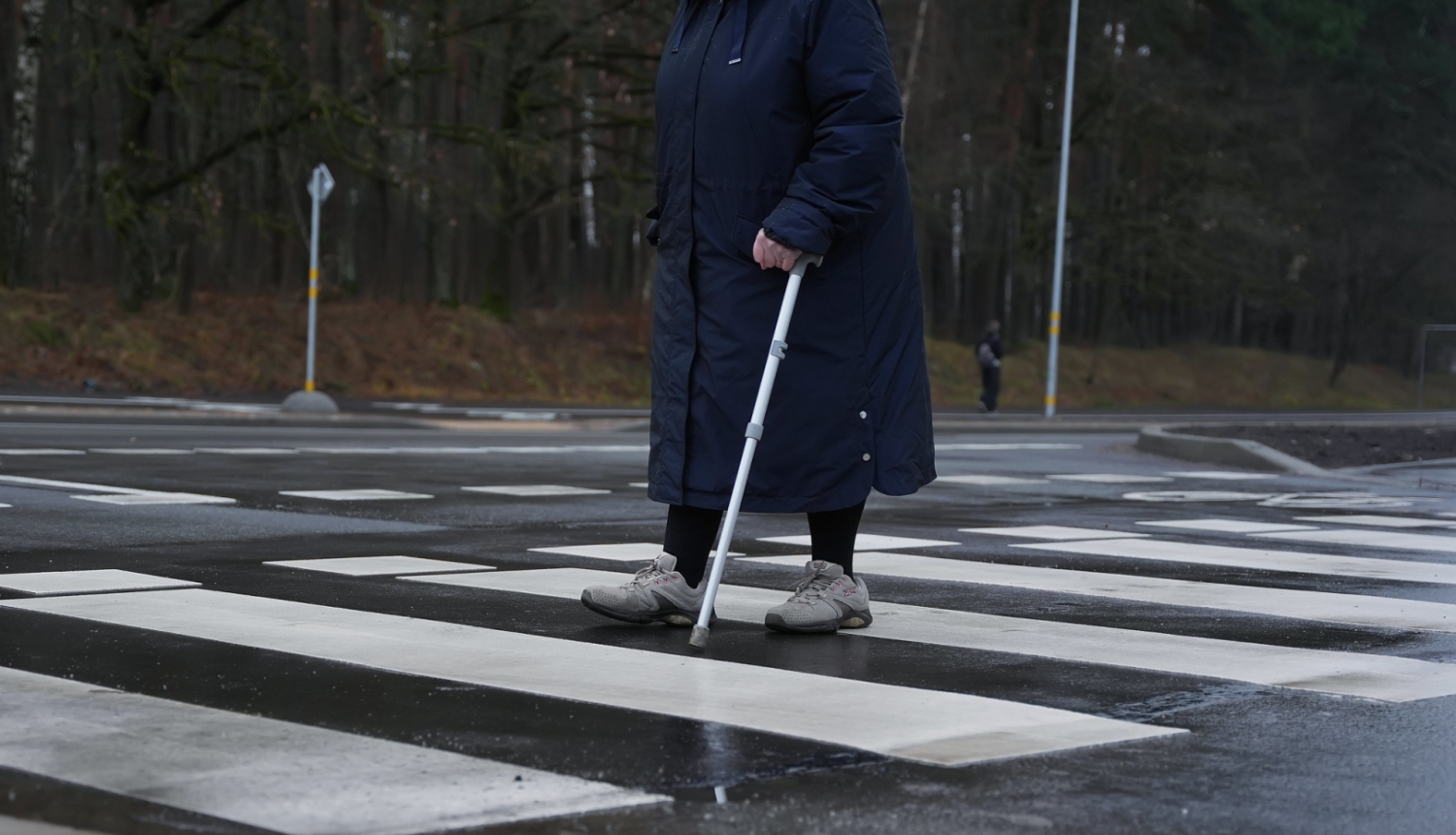 Cilvēks iet pa gājēju pāreju