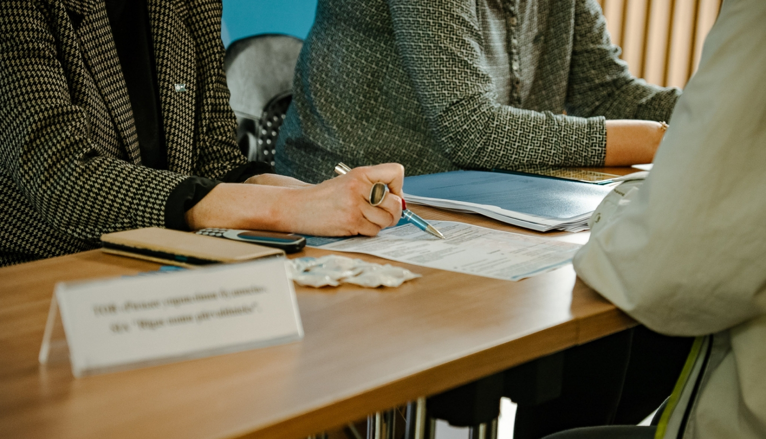 Cilvēki sēž pie galda