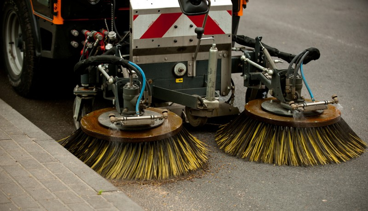 Auto ar birstēm attīra ielu no smiltīm