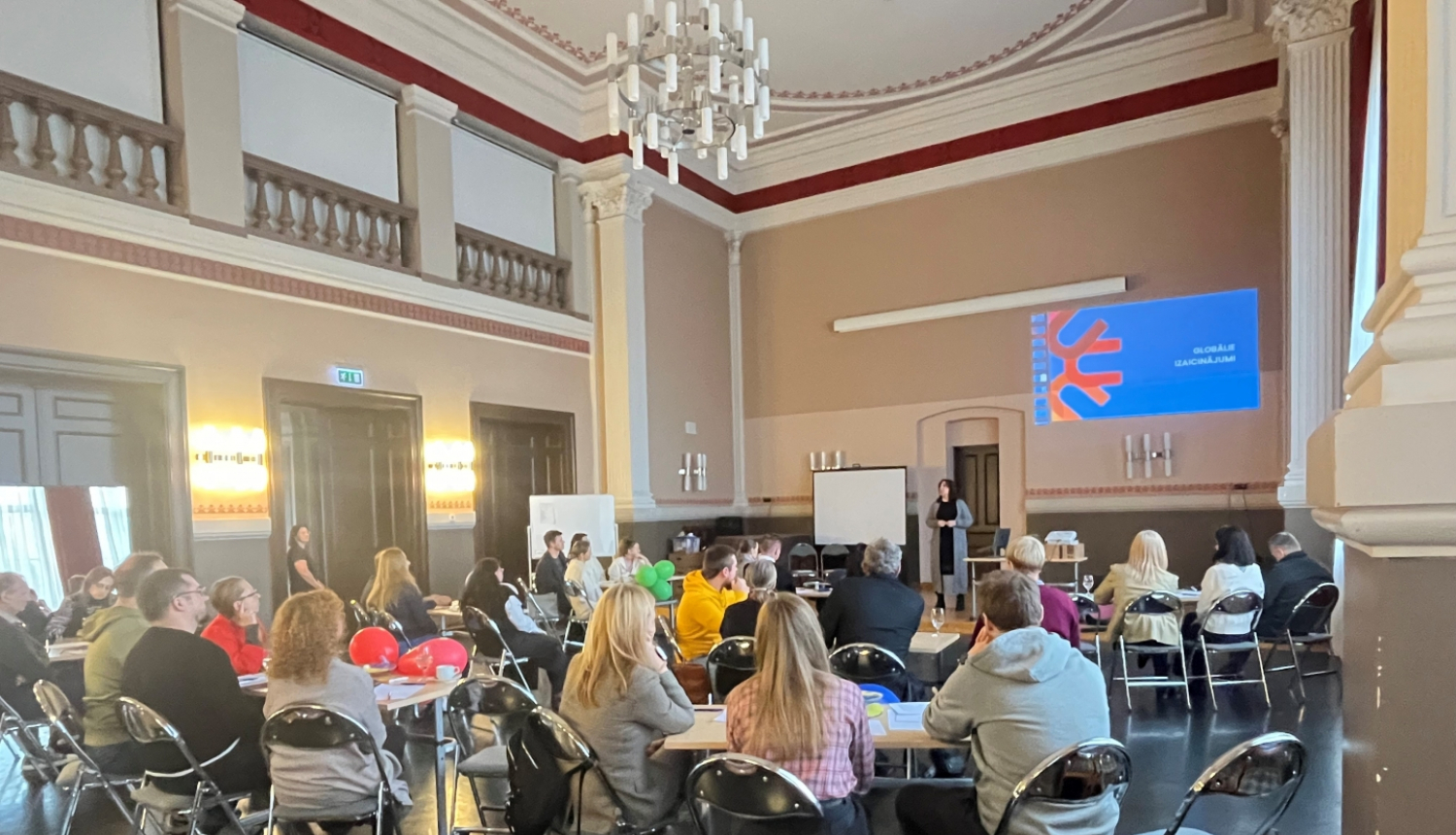 Cilvēki sēž pie galdiem