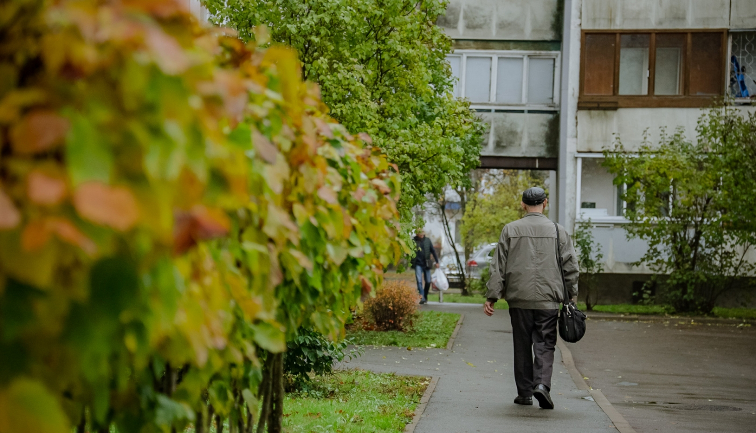 Cilvēks iet pa ielu uz māju