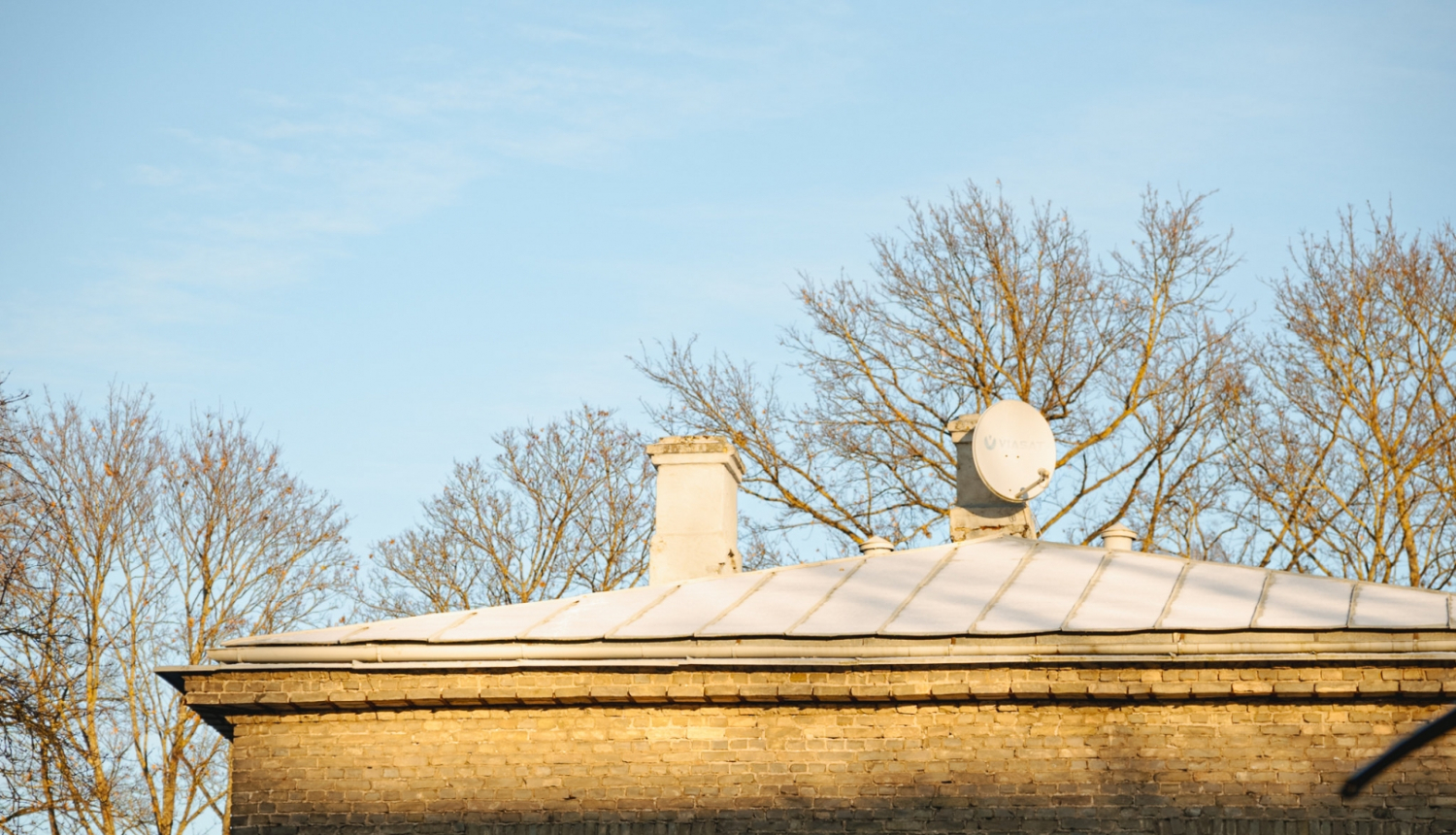 Mājas jumts ar skursteni un satelīta antenu