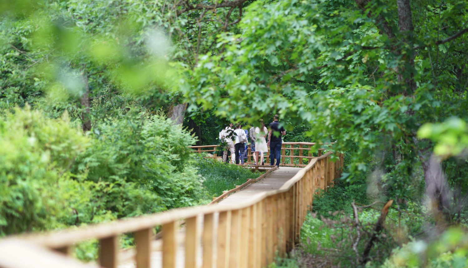 Cilvēki iet pa pastaigu taku