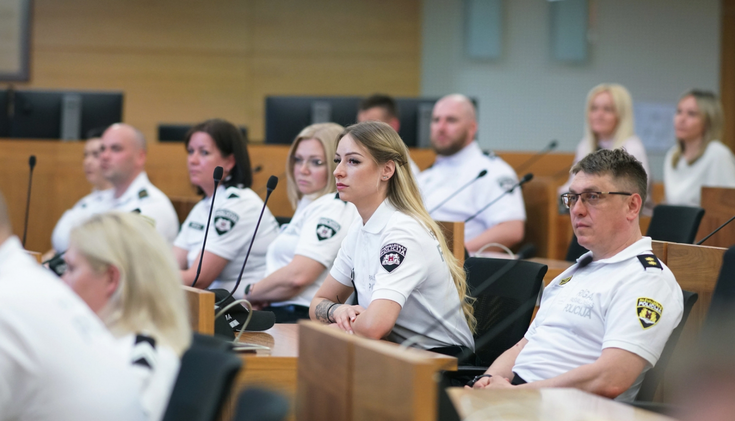 Pašvaldības policijas darbinieki sēž sēžu zālē