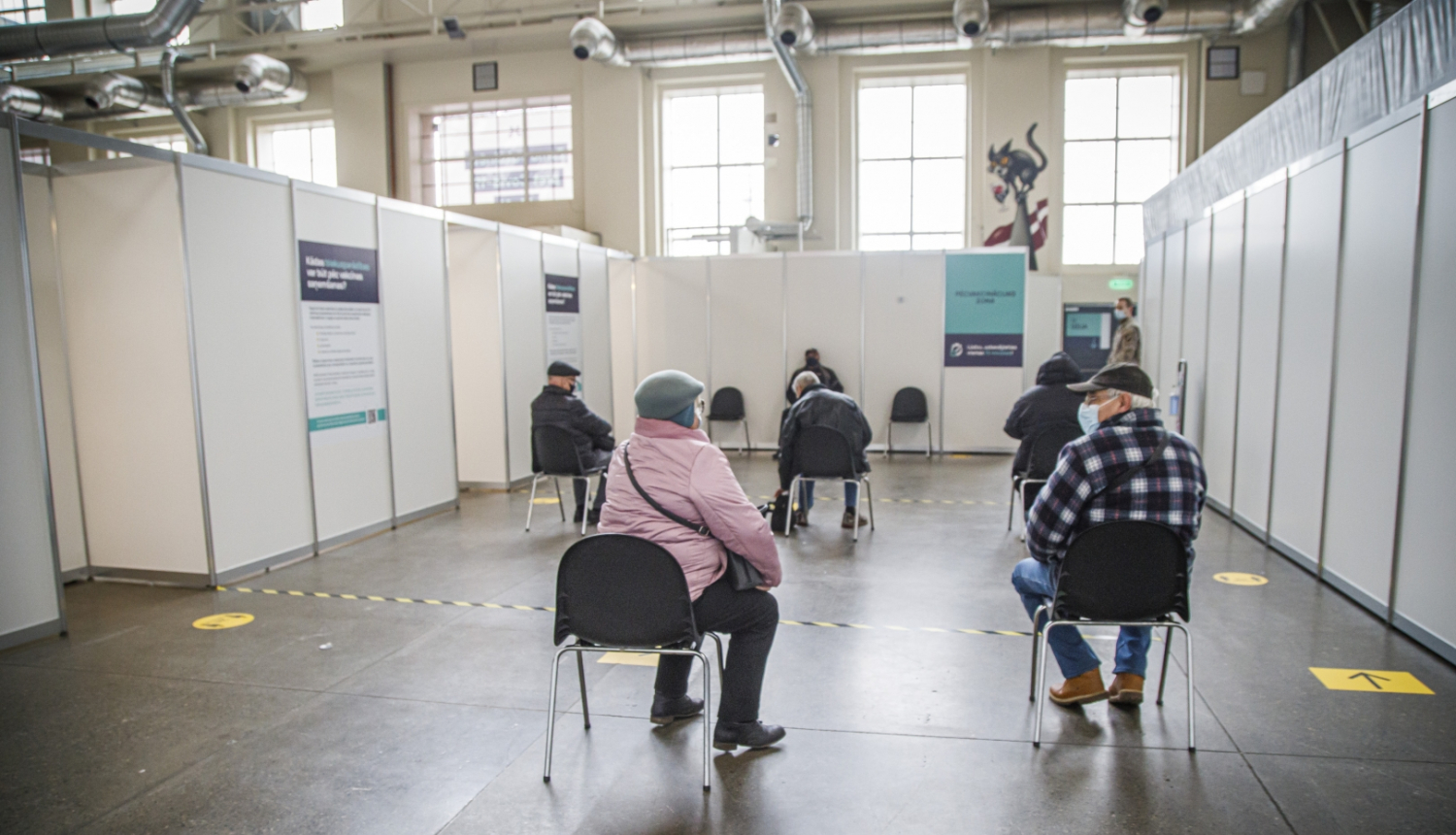 Cilvēki gaidā rindā uz vakcīnu 