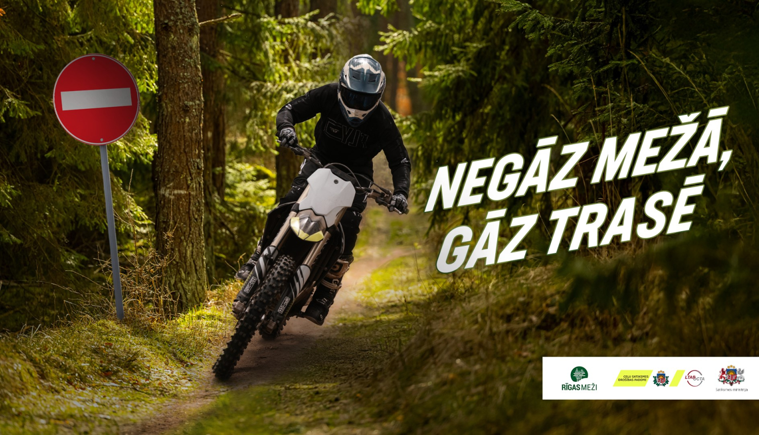 Cilvēks uz motocikla mežā