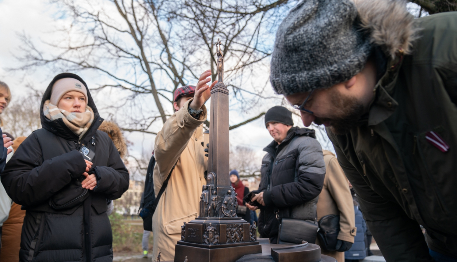 Cilvēki apskata tkatilo Brīvības pieminekli