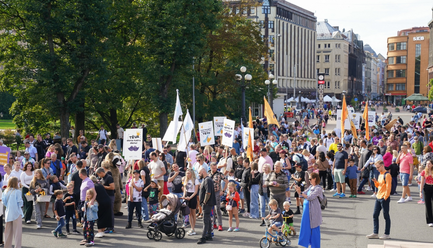 Cilvēki iet gājienā gar Brīvības pieminekli