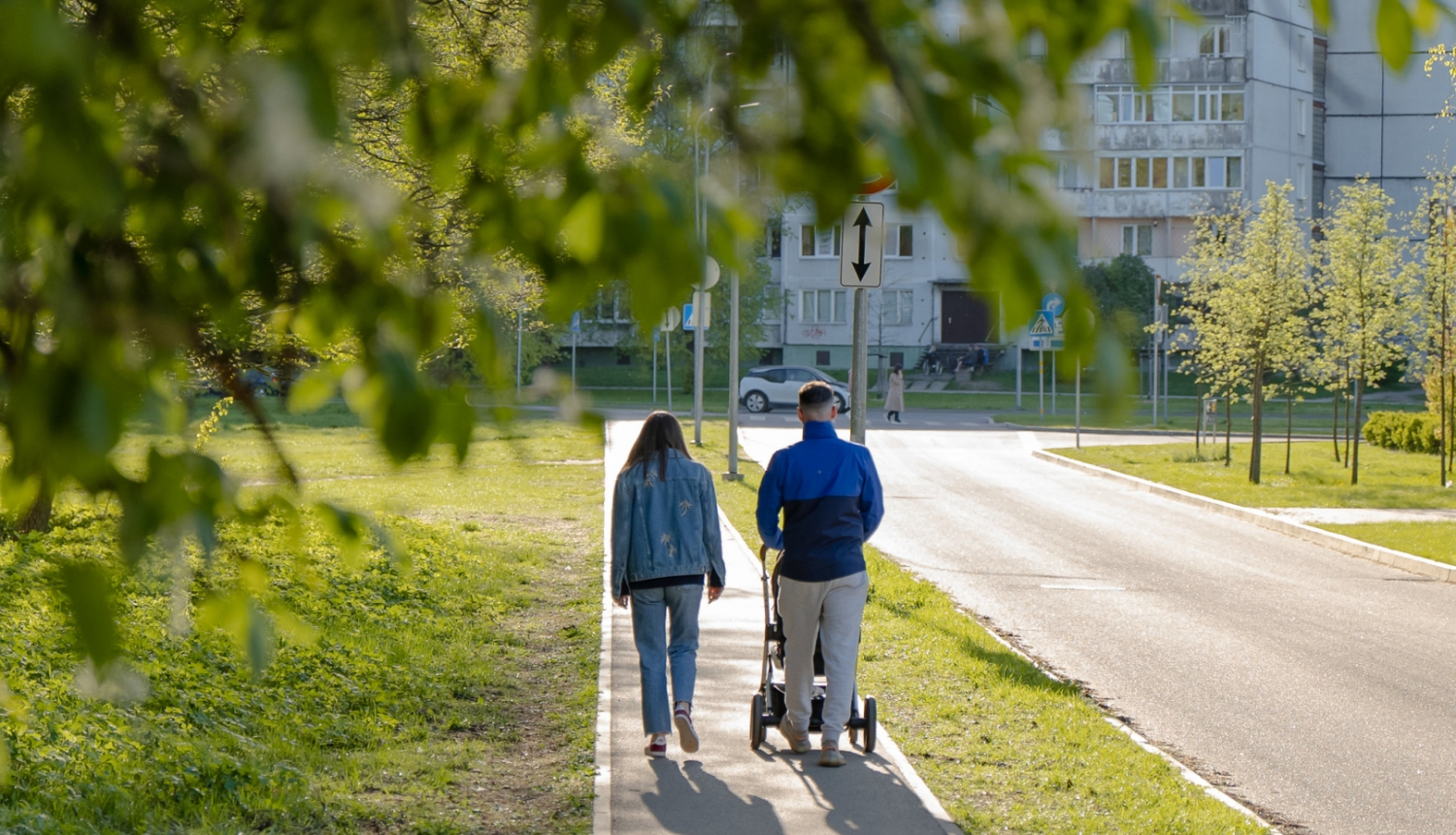 Vecāki pastaigājas ar bērnu ratiņos