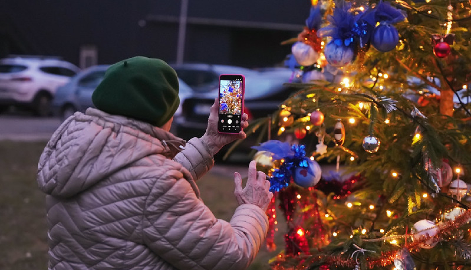 Sieviete fotografē Ziemassvētku egli
