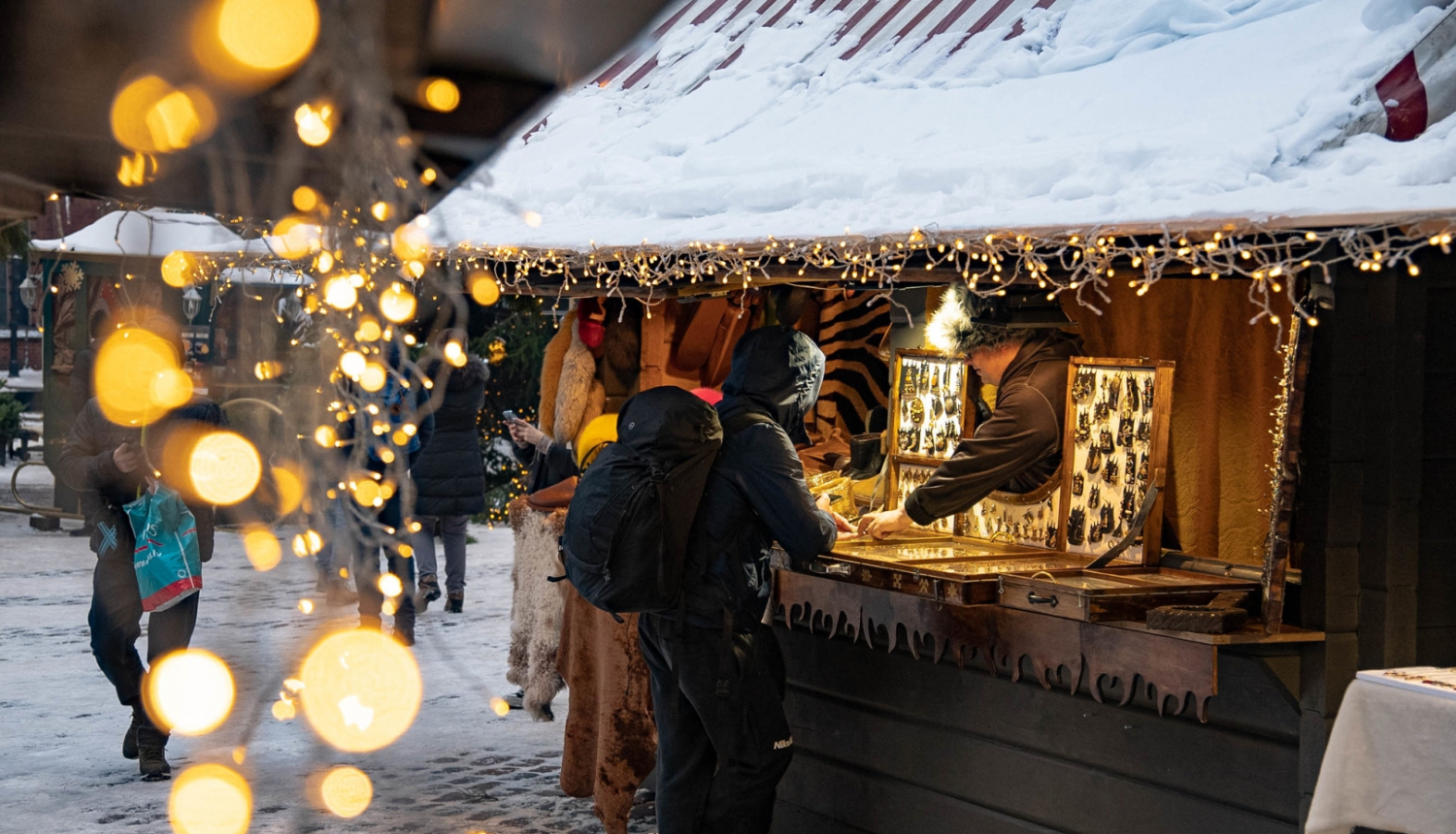 Ziemasvētku tirdziņa būdiņa ar pircēju